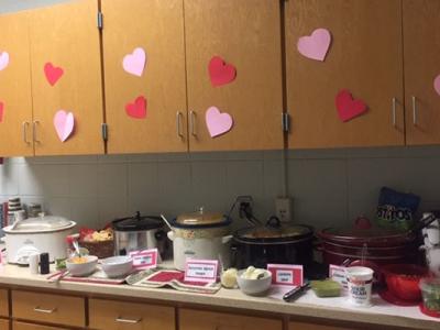several crockpots are surrounded by heart decorations